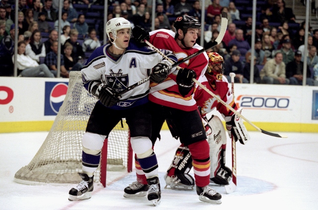 11 Mar 2000: Luc Robitaille #20 of the Los Angeles Kings watches the puck after hitting it as Robyn Regehr #28 of the Calgary Flames gaurds him during the game at the Staples Center in Los Angeles, California. The Kings defeated the Flames 3-1.