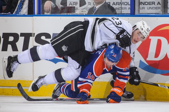 EDMONTON, AB - MARCH 09: Jordan Eberle #14 of the Edmonton Oilers collides with Dustin Brown #23 of the Los Angeles Kings during an NHL game at Rexall Place on March 09, 2014 in Edmonton, Alberta, Canada. The Kings defeated the Oilers 4-2.(Photo by Derek