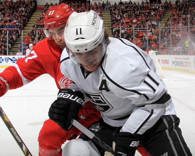 DETROIT, MI - JANUARY 18:  Kyle Quincey #27 of the Detroit Red Wings and Anze Kopitar #11 of the Los Angeles Kings battle in the corner for the puck during an NHL game on January 18, 2014 at Joe Louis Arena in Detroit, Michigan. (Photo by Dave Reginek/NHL